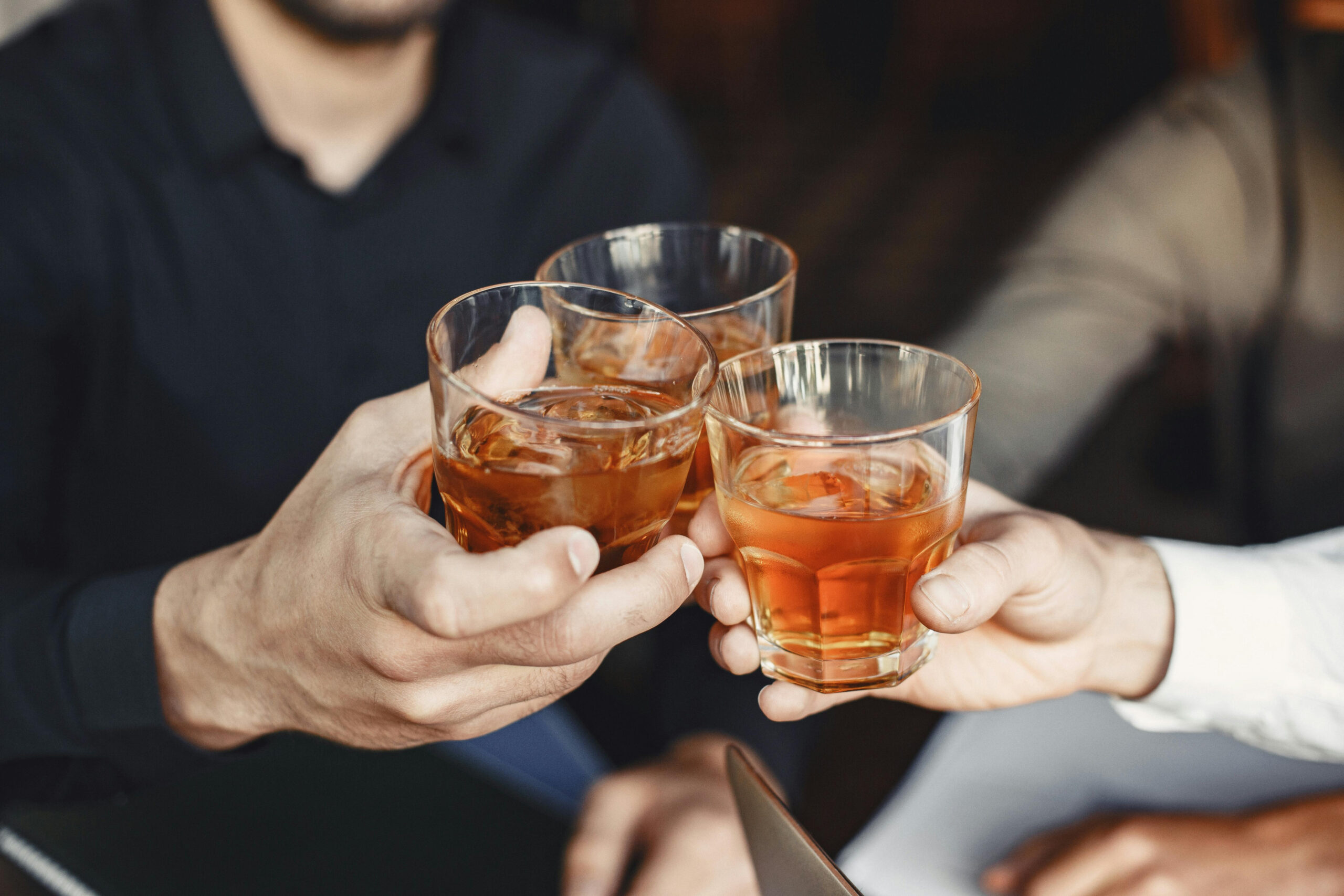People toasting with glasses of whiskey